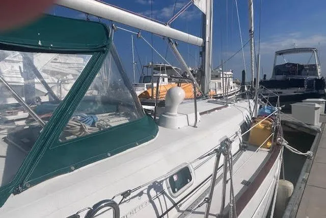 Slide: The Image of Beneteau Oceanis 461 sailboat docked, 2001 model, with green canopy and clear skies. - 6