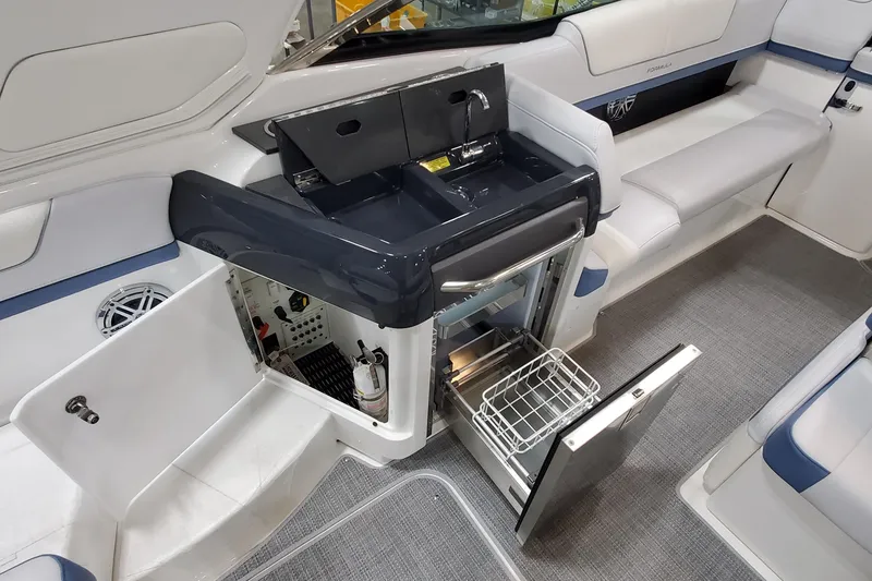 Slide: The Image of 2020 Formula 310 Bowrider interior with sink, storage, and seating area. - 15