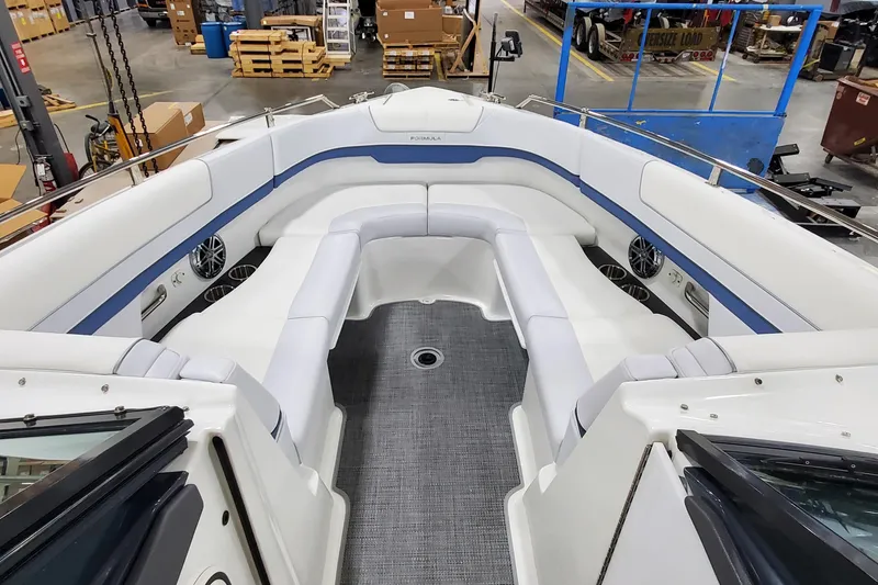 Slide: The Image of 2020 Formula 310 Bowrider interior with white seating and blue accents in a warehouse setting. - 28