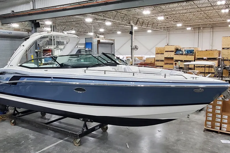 Slide: The Image of 2020 Formula 310 Bowrider boat in a warehouse, showcasing sleek design and blue exterior. - 3