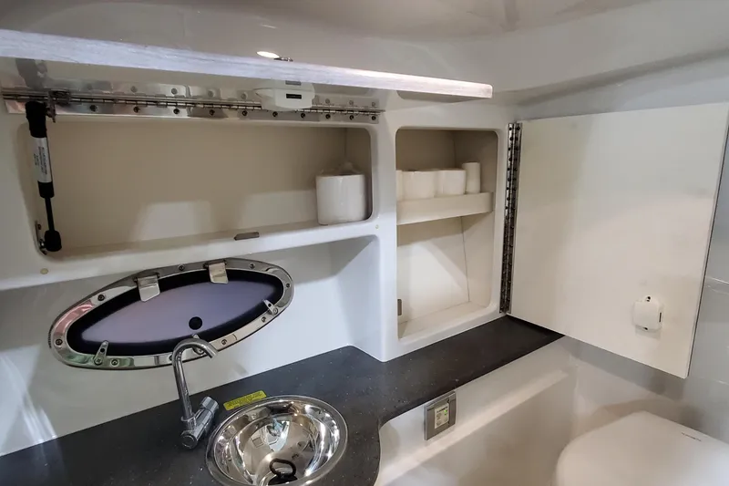 Slide: The Image of 2020 Formula 310 Bowrider bathroom with sink, storage, and porthole window. - 34
