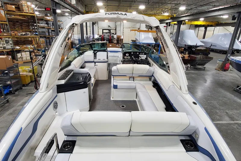Slide: The Image of 2020 Formula 310 Bowrider boat interior in a warehouse, featuring spacious seating and modern design. - 4