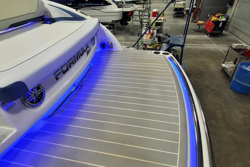 Slide: The Image of 2020 Formula 310 Bowrider boat with illuminated deck in a workshop setting. - 42