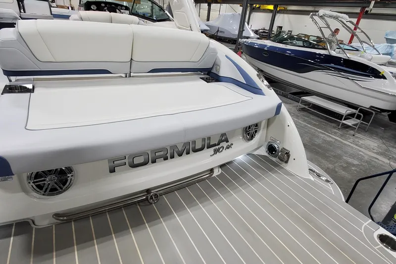 Slide: The Image of 2020 Formula 310 Bowrider boat in showroom, featuring sleek design and spacious seating. - 7