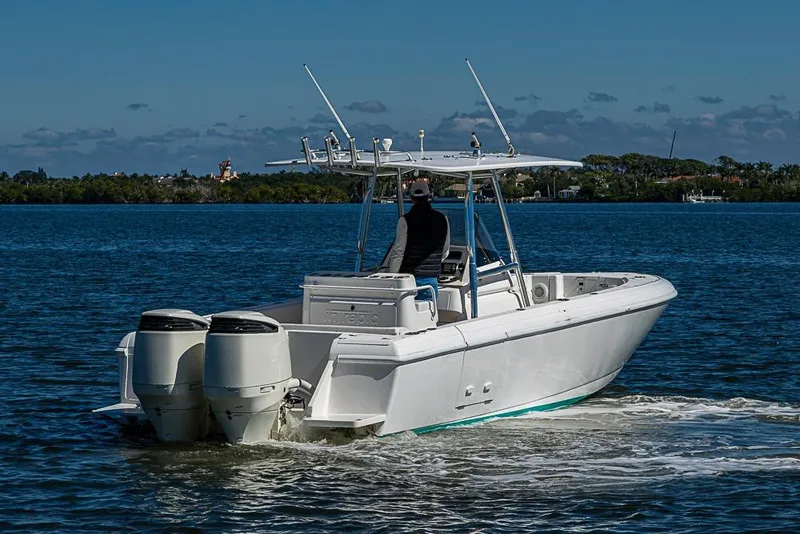 Slide: The Image of 2005 Intrepid 300 Center Console boat cruising on a calm lake under a clear sky. - 10