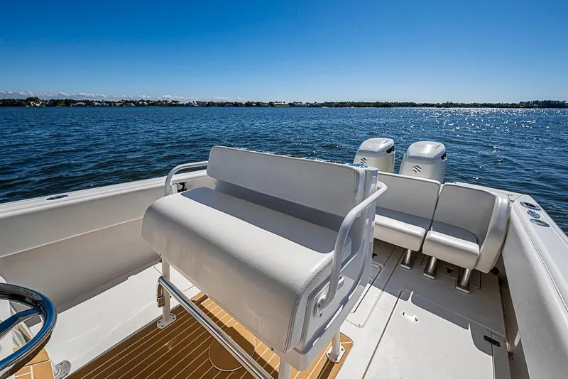 Slide: The Image of 2005 Intrepid 300 Center Console boat on calm water, featuring sleek seating and dual engines. - 17