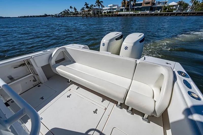 Slide: The Image of 2005 Intrepid 300 Center Console boat with white seating and dual engines on the water. - 20