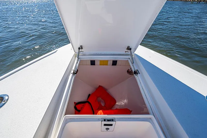 Slide: The Image of Open storage compartment on 2005 Intrepid 300 Center Console boat with life jacket inside. - 25