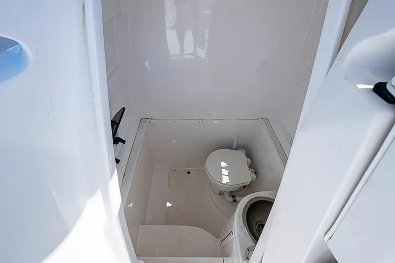 Slide: The Image of 2005 Intrepid 300 Center Console boat interior with compact marine toilet and sink. - 29