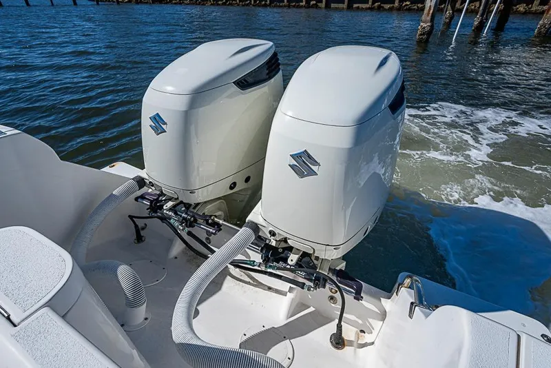 Slide: The Image of Twin Suzuki outboard engines on a 2005 Intrepid 300 Center Console boat in water. - 31