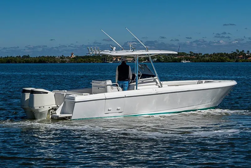 Slide: The Image of 2005 Intrepid 300 Center Console boat cruising on a calm, scenic waterway. - 9