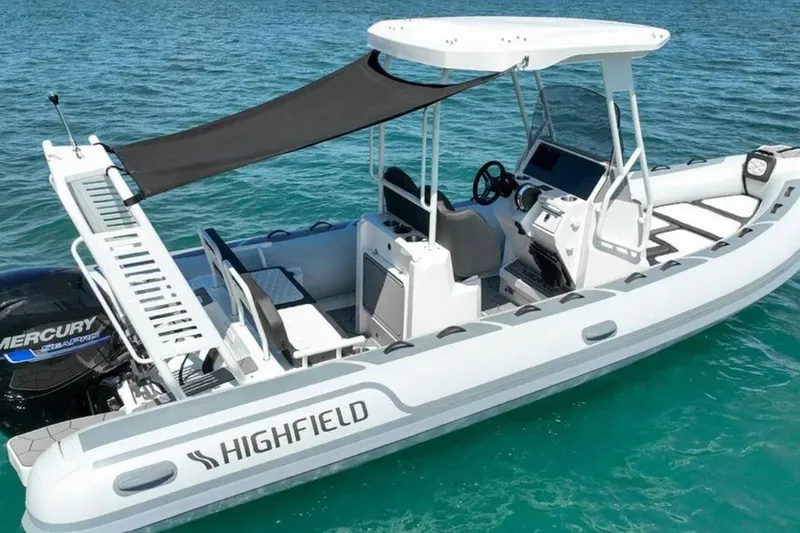 Slide: The Image of 2026 Highfield Sport 660 boat on clear blue water, featuring a Mercury engine. - 2