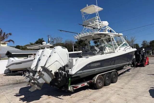Slide: The Image of 2008 Everglades 350LX boat on trailer with triple outboard engines, parked outdoors. - 5