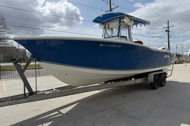 Slide: The Image of 2007 Sea Pro 270 Center Console boat on trailer, blue and white design, parked outdoors. - 6