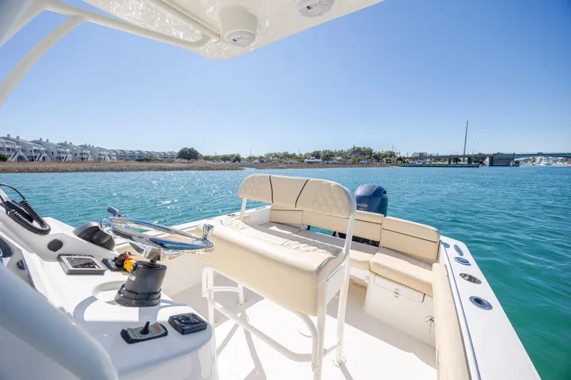 Slide: The Image of 2022 Century Coronado boat interior with steering wheel, seats, and scenic waterfront view. - 11