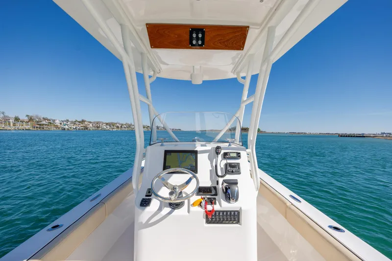 Slide: The Image of Century Coronado 2022 boat dashboard with steering wheel, navigation controls, and ocean view. - 13