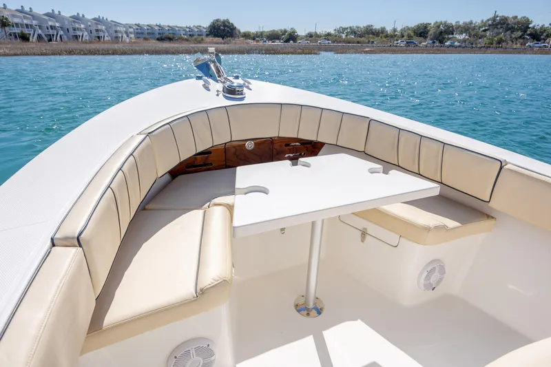 Slide: The Image of Century Coronado 2022 boat interior with cushioned seating and table on calm water. - 17