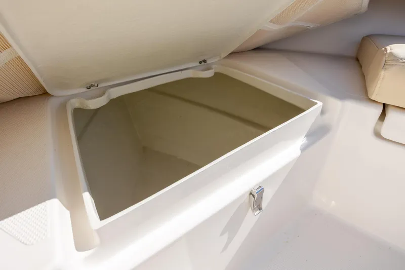 Slide: The Image of Open storage compartment on 2022 Century Coronado boat, featuring beige interior and latch. - 24
