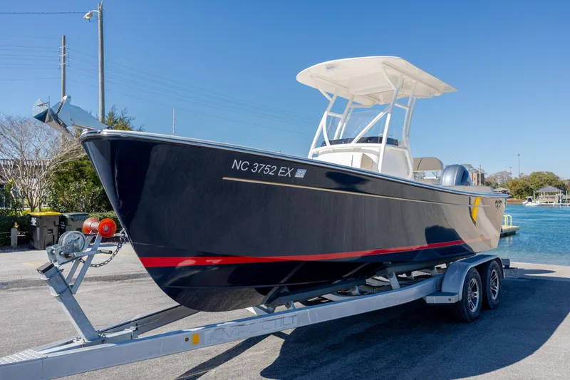 Slide: The Image of 2022 Century Coronado boat on trailer by waterfront, clear sky background. - 31