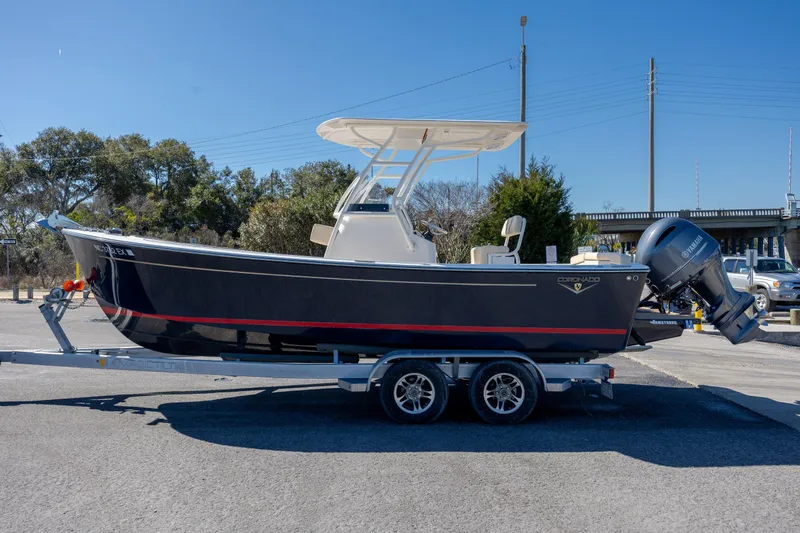 Slide: The Image of 2022 Century Coronado boat on trailer, parked outdoors, featuring sleek design and Yamaha outboard motor. - 34