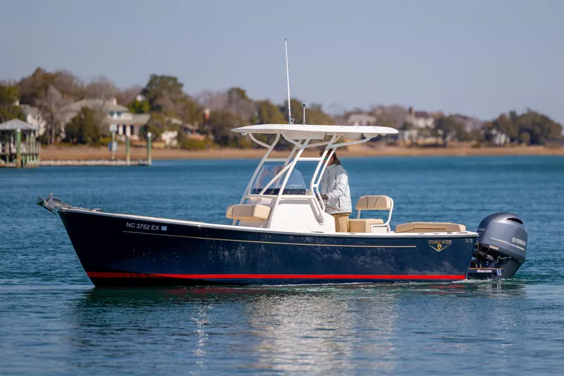 Slide: The Image of 2022 Century Coronado boat cruising on a calm lake with scenic background. - 6