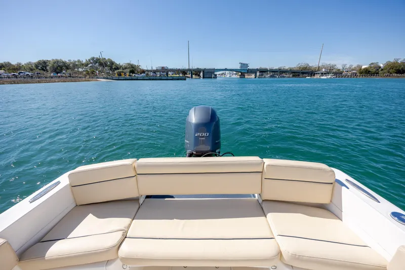 Slide: The Image of 2022 Century Coronado boat with beige seating, cruising on clear blue water. - 8