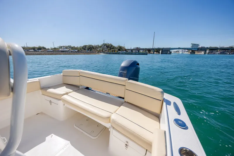 Slide: The Image of 2022 Century Coronado boat with beige seating, cruising on clear blue water near a bridge. - 9