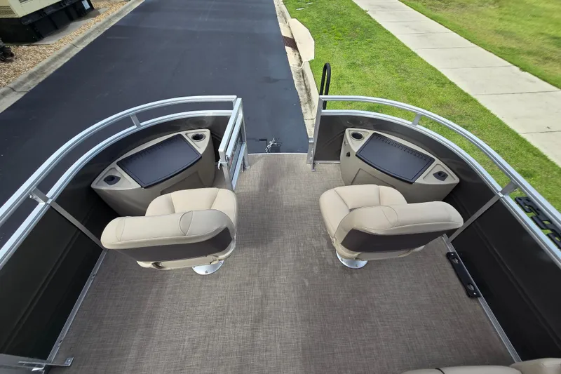 Slide: The Image of 2026 Sun Tracker Sportfish 24 XP3 boat interior with two beige seats and storage compartments. - 91