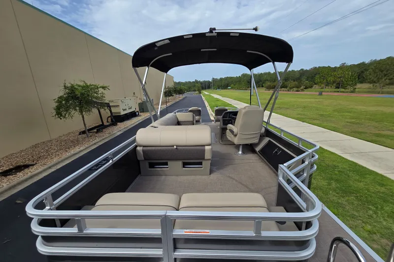 Slide: The Image of 2026 Sun Tracker Sportfish 24 XP3 pontoon boat with canopy, beige seating, and spacious deck. - 92