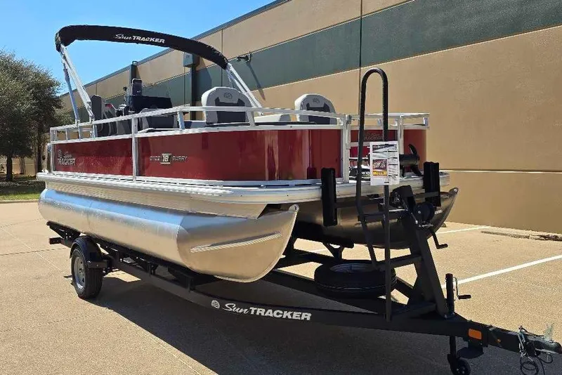 The Image of 2026 Sun Tracker Bass Buggy 18 DLX pontoon boat on trailer, parked outdoors. - 0