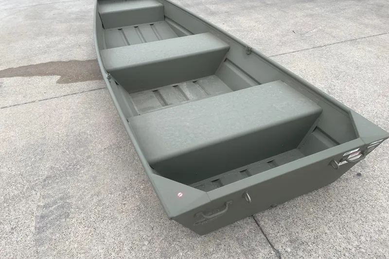 The Image of 2026 Tracker Grizzly 12 Jon boat on concrete surface, showcasing interior seating and design. - 0