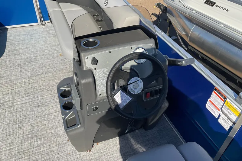 Slide: The Image of 2026 Sun Tracker Party Barge 16 DLX steering console with cup holders and seating. - 69