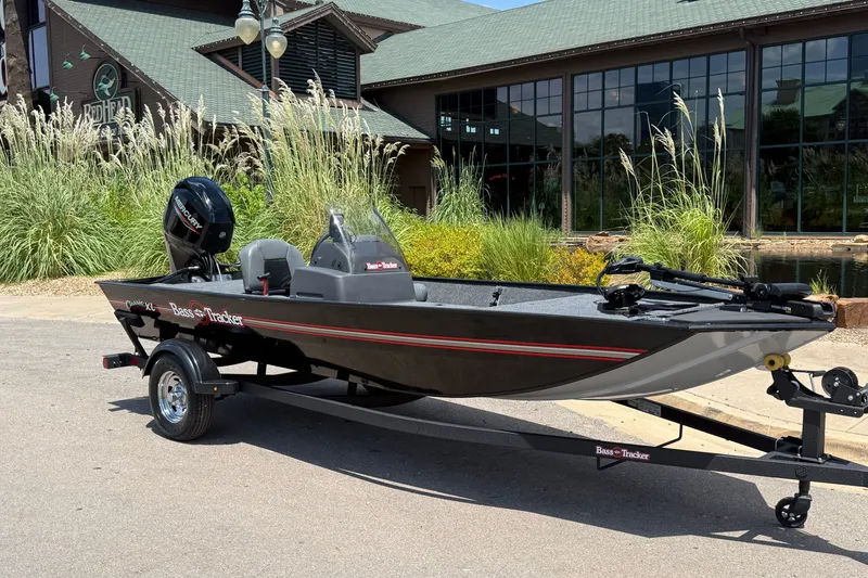 Slide: The Image of 2026 Tracker Bass Tracker Classic XL boat on trailer, parked outdoors near greenery. - 5