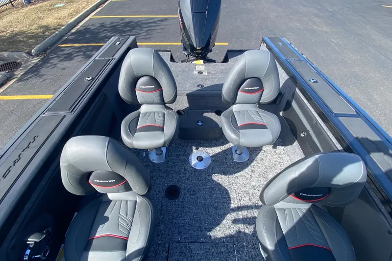 Slide: The Image of 2026 Tracker Targa V-19 Combo boat interior with four gray seats in a parking lot. - 77