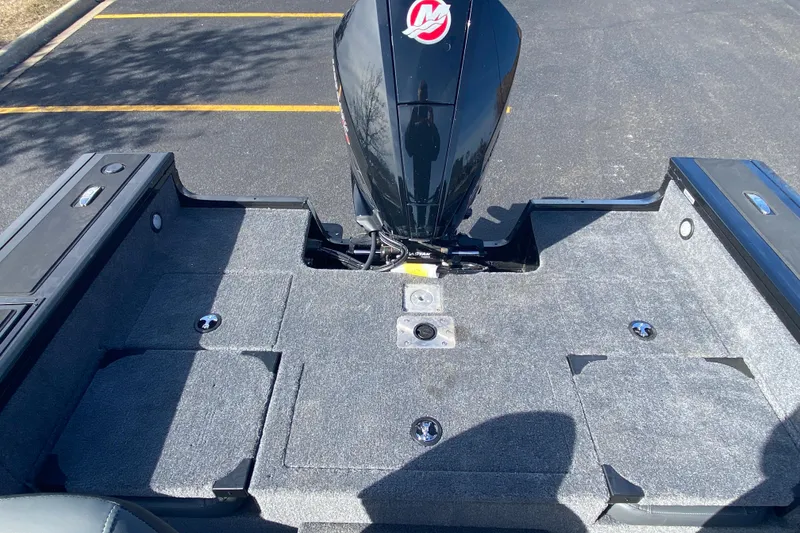 Slide: The Image of 2026 Tracker Targa V-19 Combo boat deck with motor, parked on asphalt. - 78