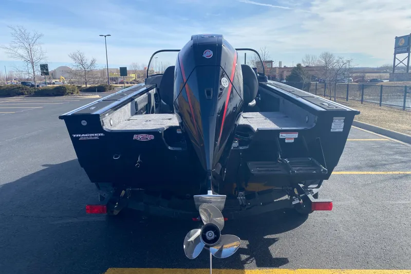 Slide: The Image of 2026 Tracker Targa V-19 Combo boat parked in a lot, rear view with motor visible. - 71