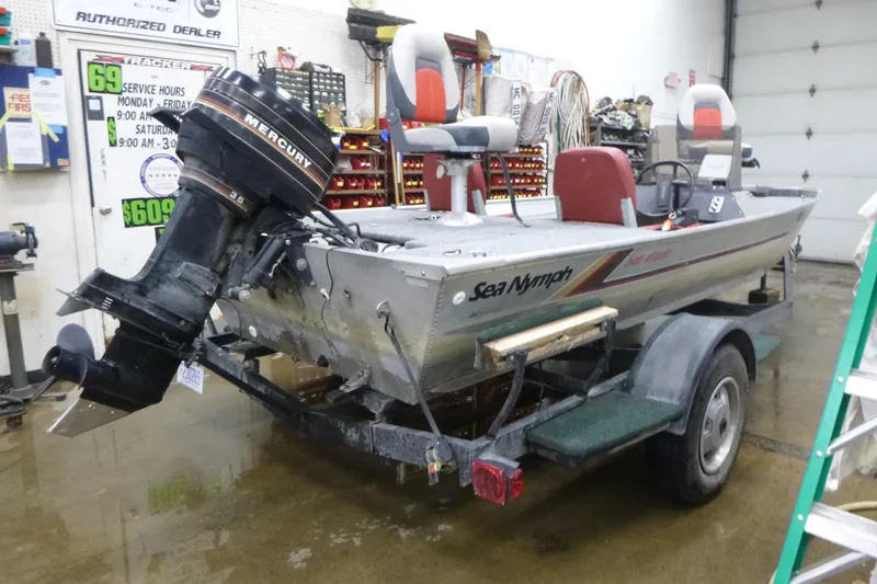 Slide: The Image of 1988 Sea Nymph TX170 boat with Mercury outboard motor in a garage setting. - 3