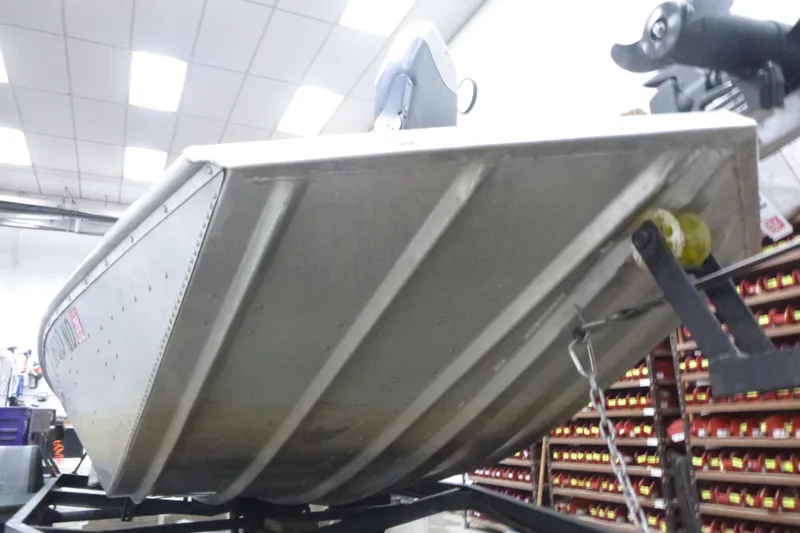 Slide: The Image of 1988 Sea Nymph TX170 boat in workshop, viewed from below, showcasing hull design. - 6