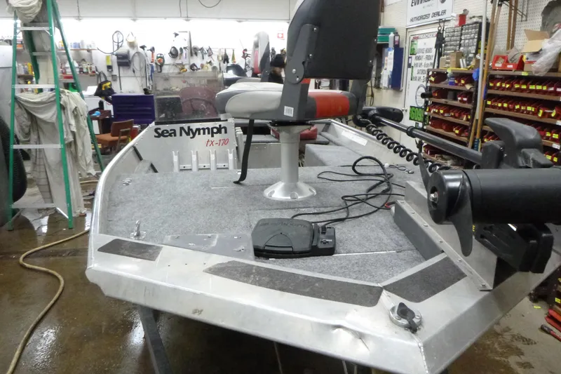Slide: The Image of 1988 Sea Nymph TX170 boat in workshop, featuring a mounted seat and trolling motor. - 7