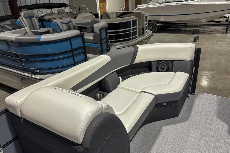 Slide: The Image of 2025 Trifecta 22RF CS pontoon boat with luxurious seating in showroom. - 13