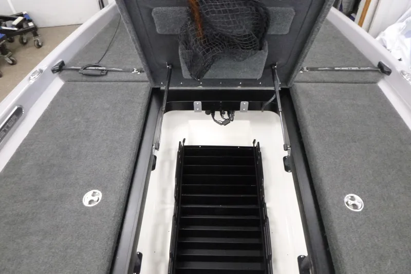 Slide: The Image of 2020 Skeeter FXR21 boat interior with open storage compartments and carpeted surfaces. - 12