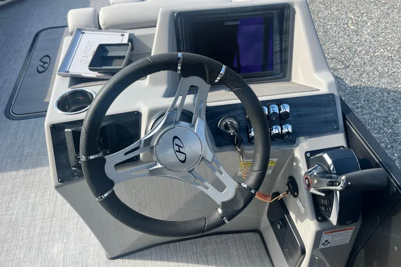 Slide: The Image of 2023 Harris Cruiser Sunliner 250 steering console with modern controls and Simrad display. - 12