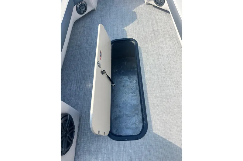 Slide: The Image of 2023 Harris Cruiser Sunliner 250 boat storage compartment with open hatch on deck. - 13
