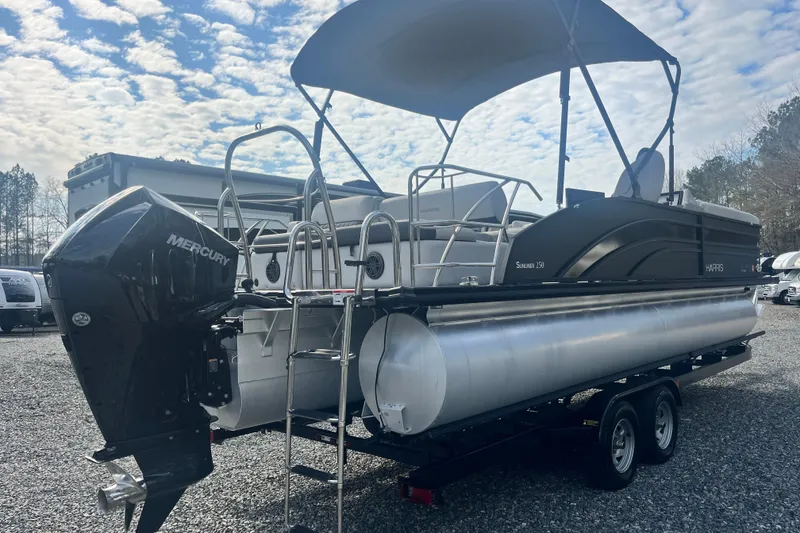 Slide: The Image of 2023 Harris Cruiser Sunliner 250 pontoon boat with Mercury engine on a trailer. - 3