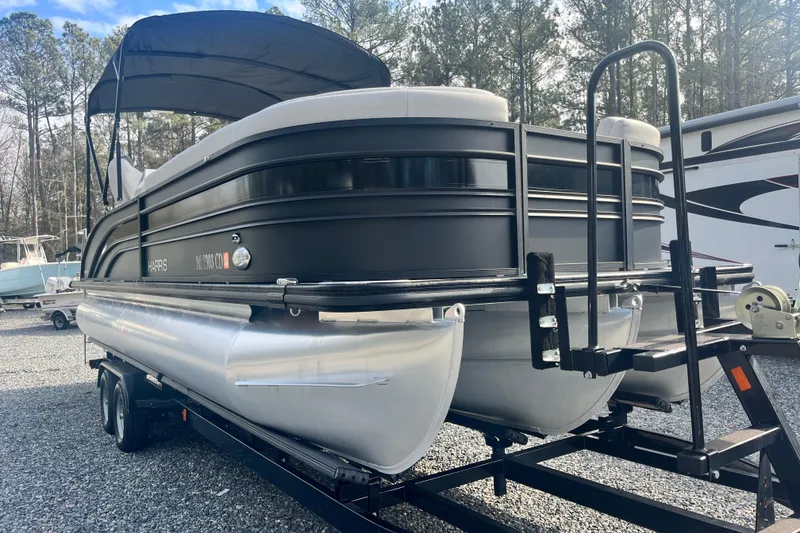 Slide: The Image of 2023 Harris Cruiser Sunliner 250 pontoon boat on trailer, parked outdoors. - 4