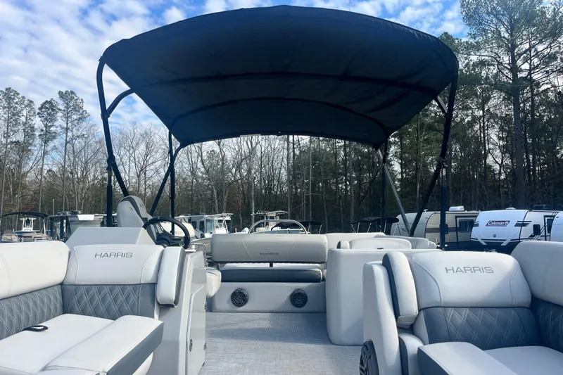 Slide: The Image of 2023 Harris Cruiser Sunliner 250 pontoon boat with canopy, featuring luxurious seating and modern design. - 6