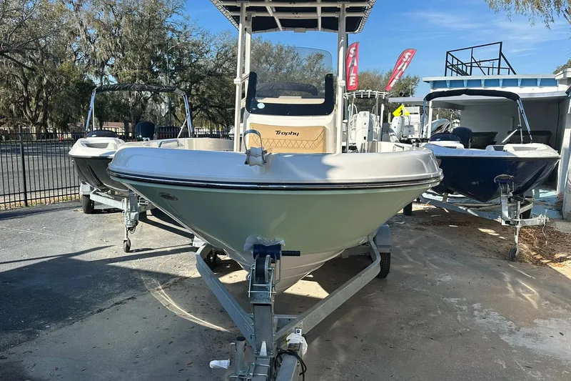 Slide: The Image of 2026 Bayliner Trophy T20CC boat on trailer, displayed outdoors with other boats. - 2