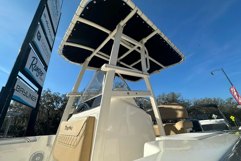 Slide: The Image of 2026 Bayliner Trophy T20CC boat with T-top, displayed outdoors under clear blue sky. - 7