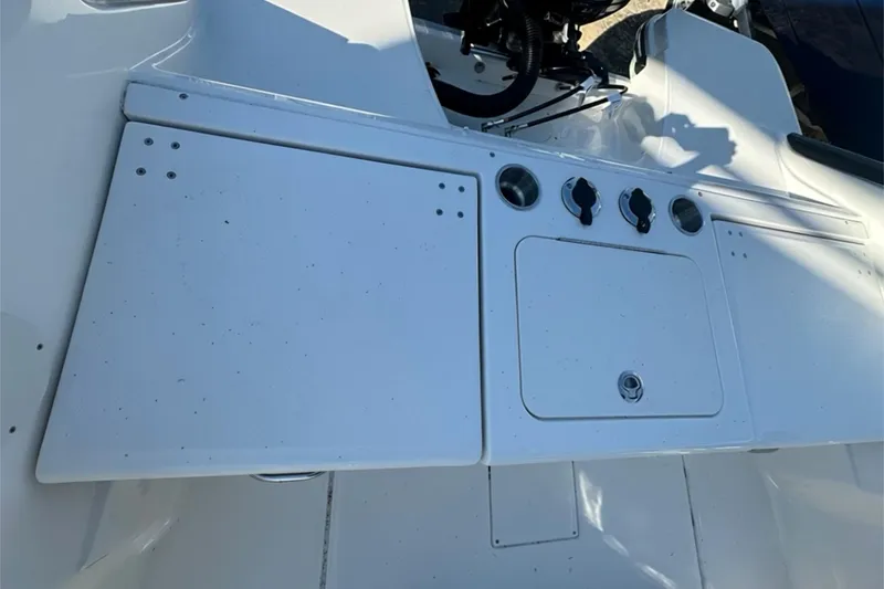Slide: The Image of 2026 Bayliner Trophy T20CC boat console with storage compartments and control knobs. - 8