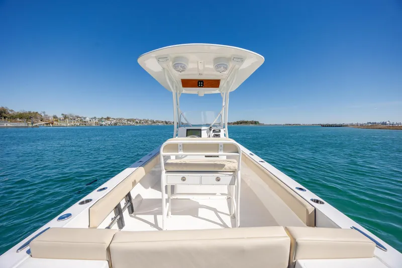 Slide: The Image of 2022 Vanquish Bristol Harbor 23 CC boat on calm blue water, clear sky. - 12